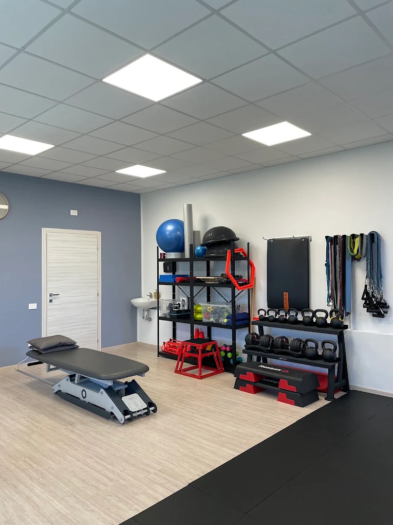 Sala dello studio di fisioterapia con lettino e attrezzature per l’esercizio