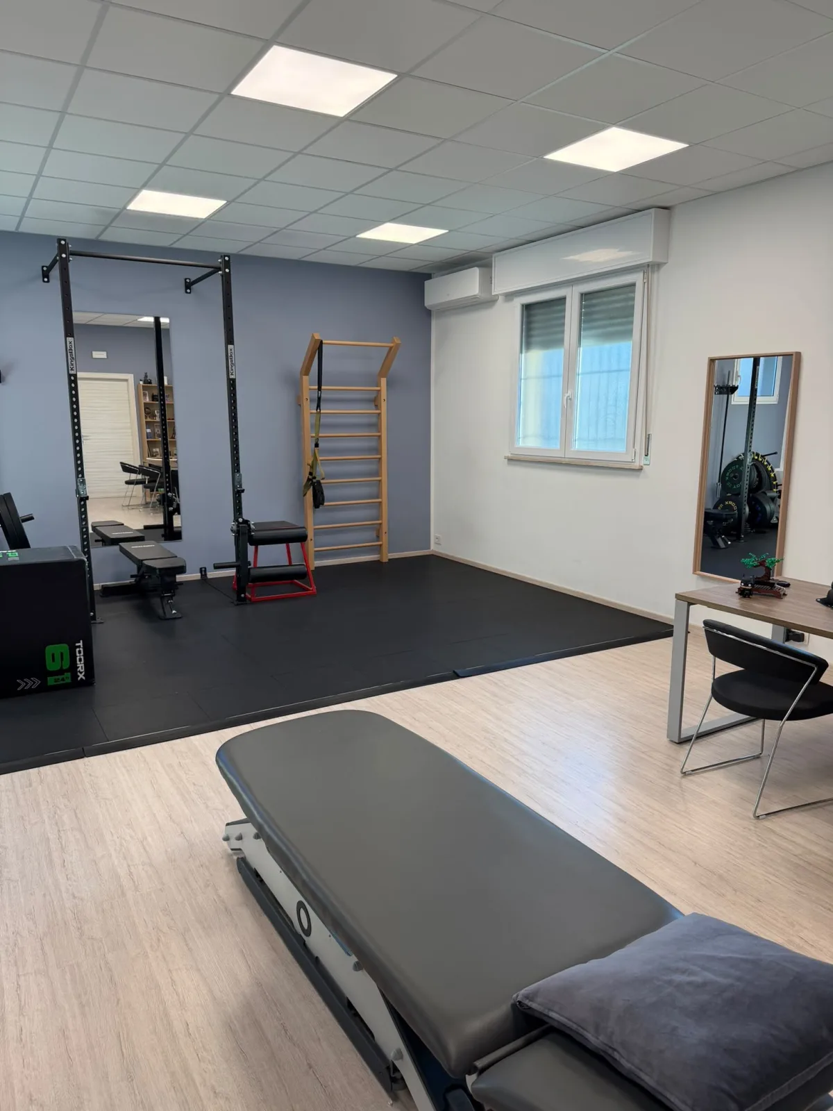 Vista dello studio con lettino, scrivania e area per l’esercizio terapeutico